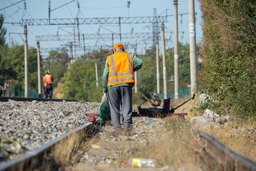 workers check for broken old reinforced concrete sleepers to replace them with new ones on the railway using equipment