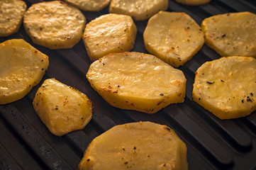 Roasting Potato on the Grill. Golden Slices Seasoned with Spices.