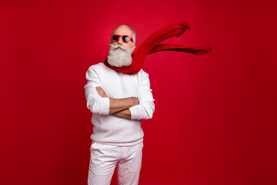 Trendy grey-haired superhero santa wear sun specs knitted clothes isolated red background