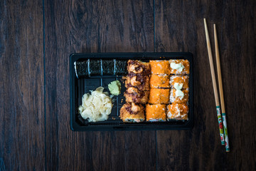 Sushi Set in Plastic Container Box / Package. California Roll, New York Roll, Boom Roll, Ginger, Wasabi and Soy Sauce.