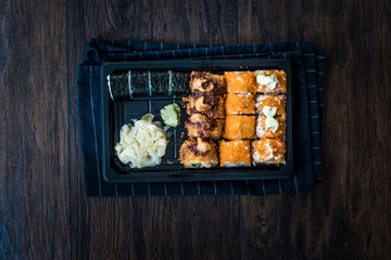 Sushi Set in Plastic Container Box / Package. California Roll, New York Roll, Boom Roll, Ginger, Wasabi and Soy Sauce.