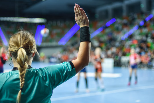 Handball referee gives signal playing for time during handball match.
