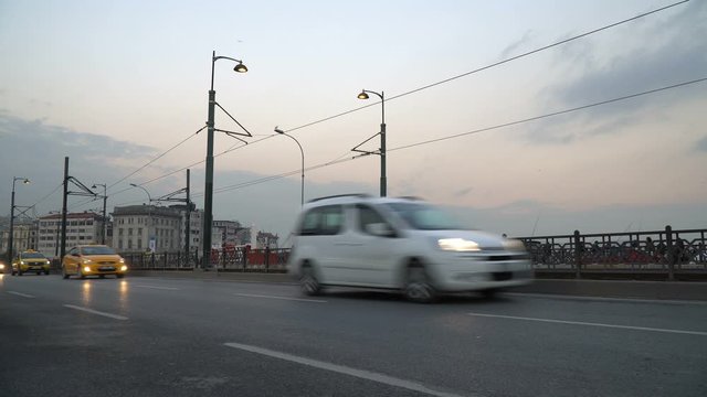 Vehicles are passing by The Galata Bridge at The Istanbul European Side in evening.