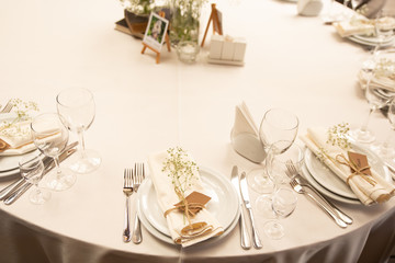 Table setting set with flowers. Modern and elegant decoration of table set for celebration with white utensil.