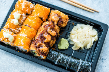 Sushi Set in Plastic Container Box / Package. California Roll, New York Roll, Boom Roll, Ginger, Wasabi and Soy Sauce.