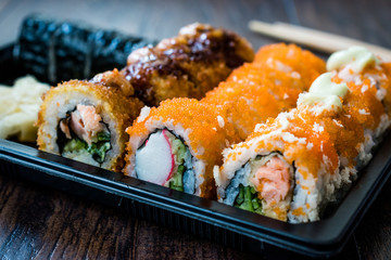 Sushi Set in Plastic Container Box / Package. California Roll, New York Roll, Boom Roll, Ginger, Wasabi and Soy Sauce.