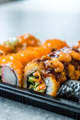 Sushi Set in Plastic Container Box / Package. California Roll, New York Roll, Boom Roll, Ginger, Wasabi and Soy Sauce.