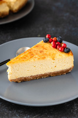 Slice of cheesecake with berries on a plate. Copy space.