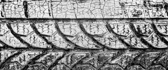 treads of a white painted car tire in the sand