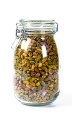 raw pistachio in a glass jar isolated on white