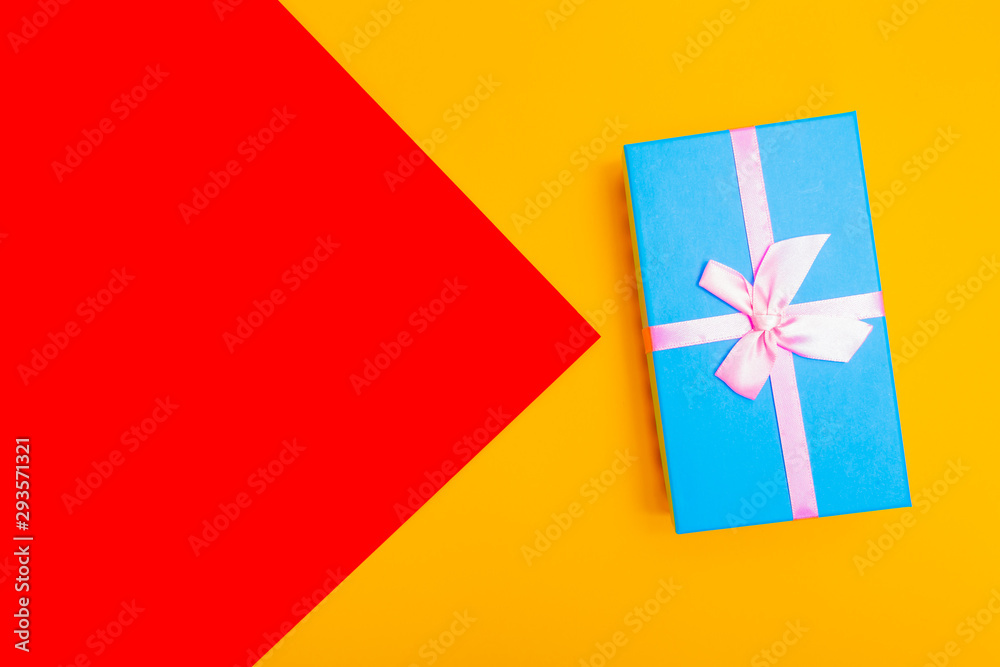 Poster gift box with ribbon on a colorful background. view from above.