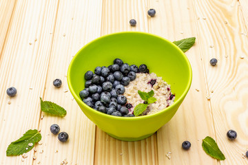 Oatmeal porridge with fresh blueberry, mint leaves and yogurt