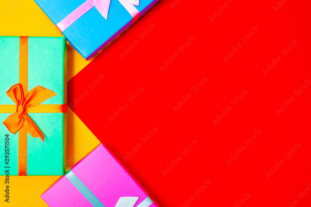 Aufkleber colored boxes with ribbons on a colorful background. view from above.