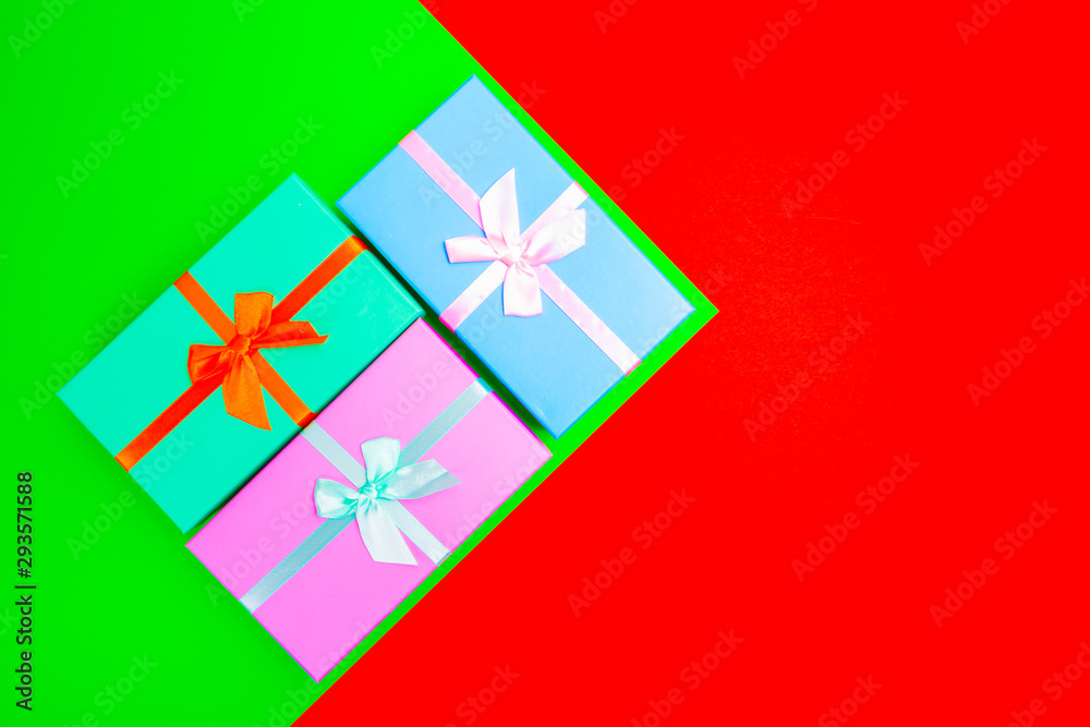 Aufkleber colored boxes with ribbons on a colorful background. view from above.
