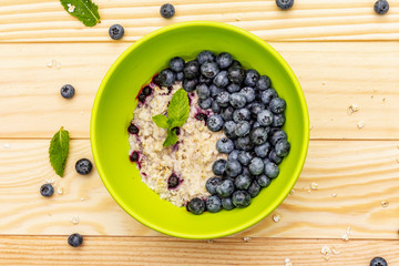 Oatmeal porridge with fresh blueberry, mint leaves and yogurt