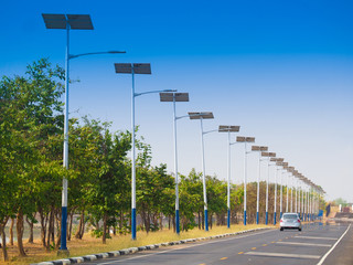 solar street light lamp post led with panel system on the road with green tree and blue sky for background energy saving concept. © jaojormami