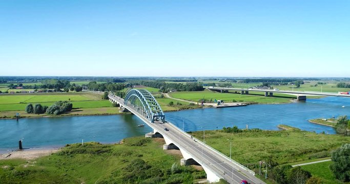 The Dutch IJssel River Near Zwolle With Two Bridges, A Slow Little Boat Going Underneath It, The Netherlands, 4K Drone Footage