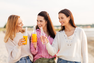 friendship and leisure concept - group of happy young women or female friends toasting non...