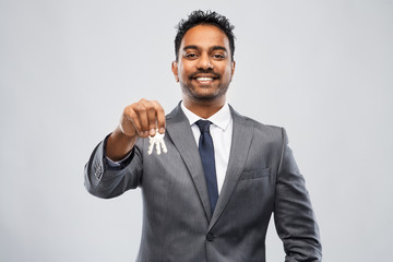 real estate business and people concept - indian man realtor with keys over grey background