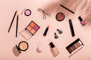 Set of makeup tools and accessory on pink background