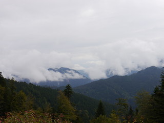 big clouds covering the panoramic view of the mountains and their autumnal forests