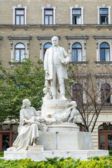 Budapest, Hungary - October 01, 2019: Mother, Child and Rescuer - Statue of doctor Ignac Semmelweis in front of Rokus Hospital. The statue is by Alajos Strobl (1906).