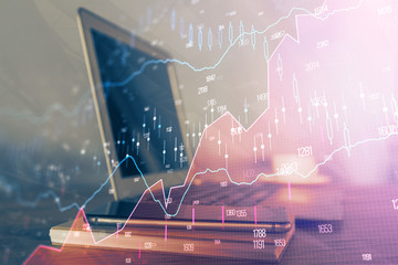 Financial graph colorful drawing and table with computer on background. Double exposure. Concept of international markets.