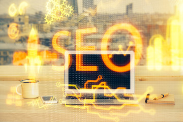 Multi exposure of table with computer and seo drawing hologram. Search optimization concept.