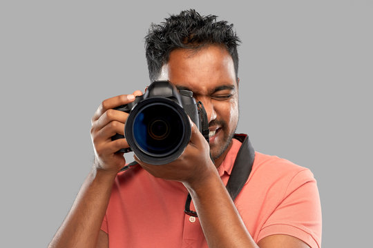 photography, profession and people and concept - happy indian man or photographer with digital camera over grey background