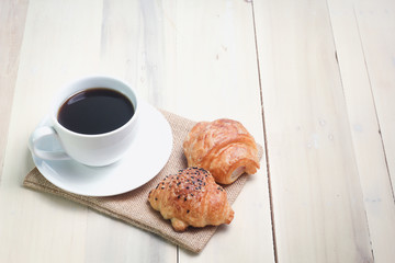 Croissant and coffee  isolated on wood table