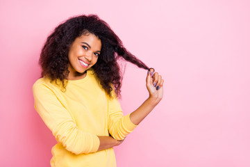 Portrait of charming positive african girl touch her hair enjoy new anti dander dandruff conditioner make her haircut glance shine wear trendy yellow jumper isolated over pink color background