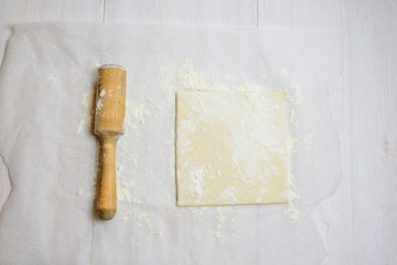 cheese puff pastry square dough and flour on the parchment with flour