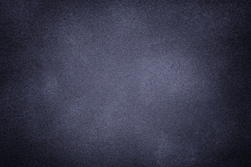 Background of dark gray and blue suede fabric closeup. Velvet matt texture of nubuck textile