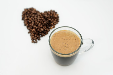 a Cup of coffee and a heart of coffee beans on a white background