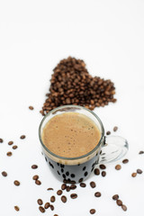 a Cup of fresh coffee and a heart made of coffee beans on a white background