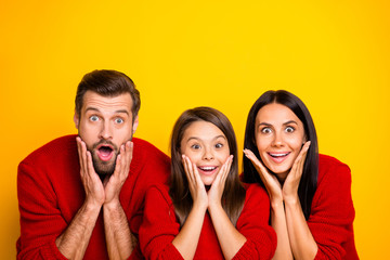 Photo of funny cheerful amazed stupor family mommy daddy excited crazy with shopping mall starting x-mas sales wearing red sweaters isolated over vivid color yellow background