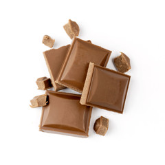 Fragments of milk chocolate isolated on white background. Broken the milk chocolate on small piece.