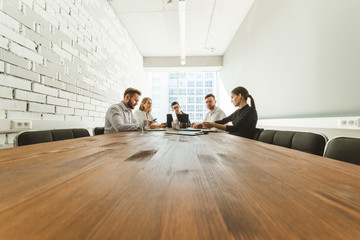 Obraz premium A team of young businessmen working and communicating together in an office. Corporate businessteam and manager in a meeting.