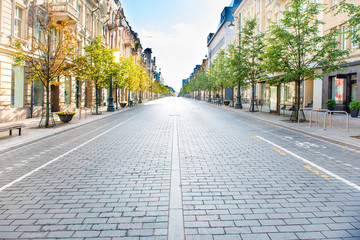 City street with empty road and morning light in Europe, Lithuania, Vilnius - obrazy, fototapety, plakaty