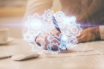 Double exposure of Man writing in notepad with business icons on background.