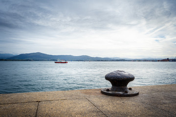 Bollard for mooring boats with boat in background