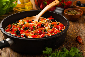 Italian spaghetti alla Pultanesca with tomatoes and olives. Served without meat and cheese.