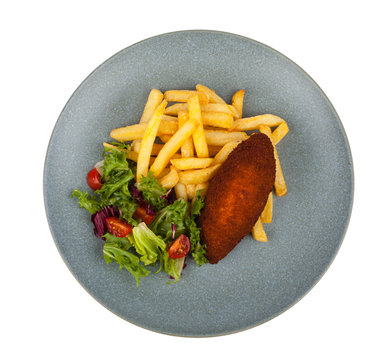 Poultry chop devolay with butter. Served with fries and green salad. Pack shot. White background.