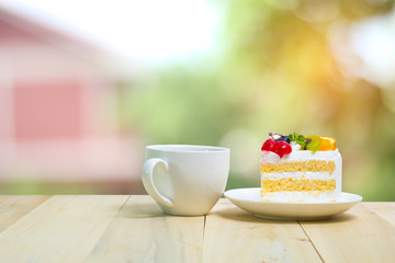 Slice cake with coffee cup on wood , green blur background