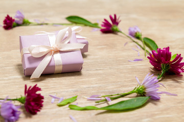 Fototapeta na wymiar Purple gift boxes. Flowers on a wooden table. Valentine's day concept. Mother's Day Scenery