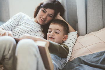 Fototapeta premium Pregnant mom playing with child in bedroom