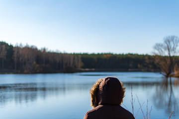 Fototapeta na wymiar Woman overviewing a lake while autumn