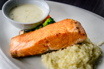 pan fried salmon chunk served with creamy rice risotto and boiled vegetables