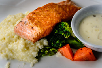 pan fried salmon chunk served with creamy rice risotto and boiled vegetables