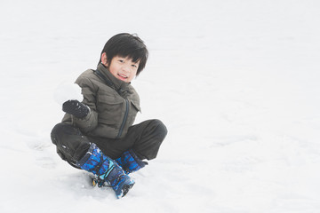 Fototapeta na wymiar Cute Asian child playing on snow in the park